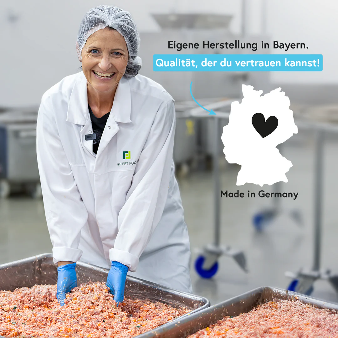 Fred & Felia founder in a white lab coat and hairnet working with food in their own manufacturing facility, with text about German production.